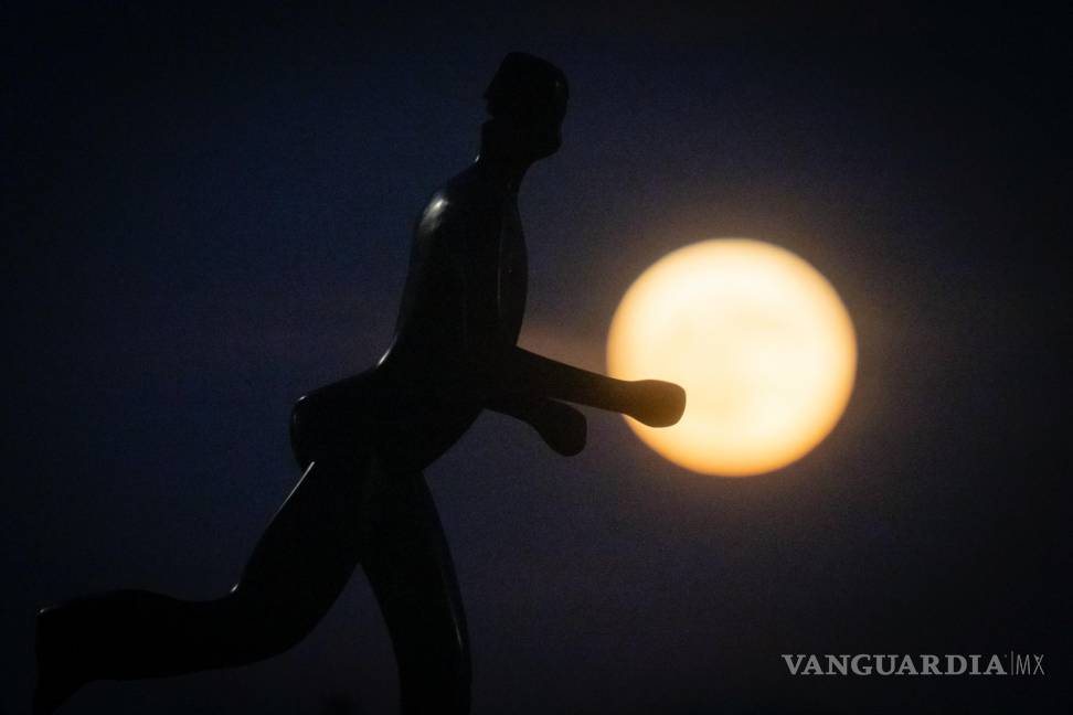 $!La silueta de una escultura de un corredor se recorta contra la superluna en Zagreb, Croacia. Durante el fenómeno conocido como la “Luna de fresa”.