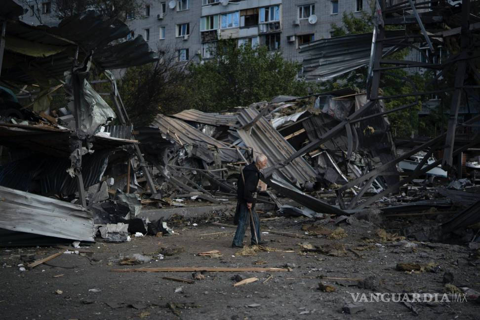 $!Un anciano pasa junto a un concesionario de autos destruido por un ataque ruso en Zaporiyia, Ucrania.