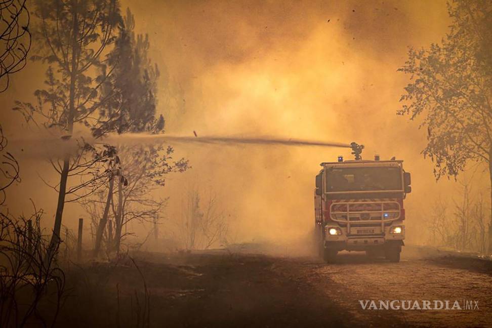 $!Esta foto proporcionada por el SDIS 33 muestra a un camión de bomberos rociando líquido sobre un incendio forestal cerca de Landiras, suroeste de Francia.