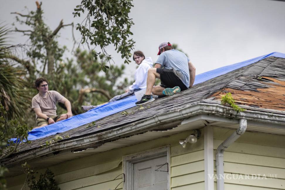 $!Los residentes reparan sus techos mientras los fuertes vientos de una banda exterior de la tormenta tropical Debby pasan sobre Isle of Palms, Carolina del Sur.