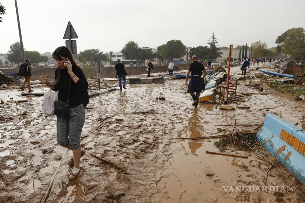 $!Una mujer camina entre el lodo acumulado por las intensas lluvias de la fuerte DANA en Picaña, Valencia.