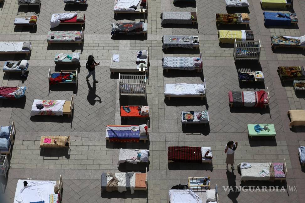 $!Personas mira algunas de las 230 camas vacías que representan a los rehenes retenidos por Hamás en Gaza en la Plaza del Municipio de Jerusalén.