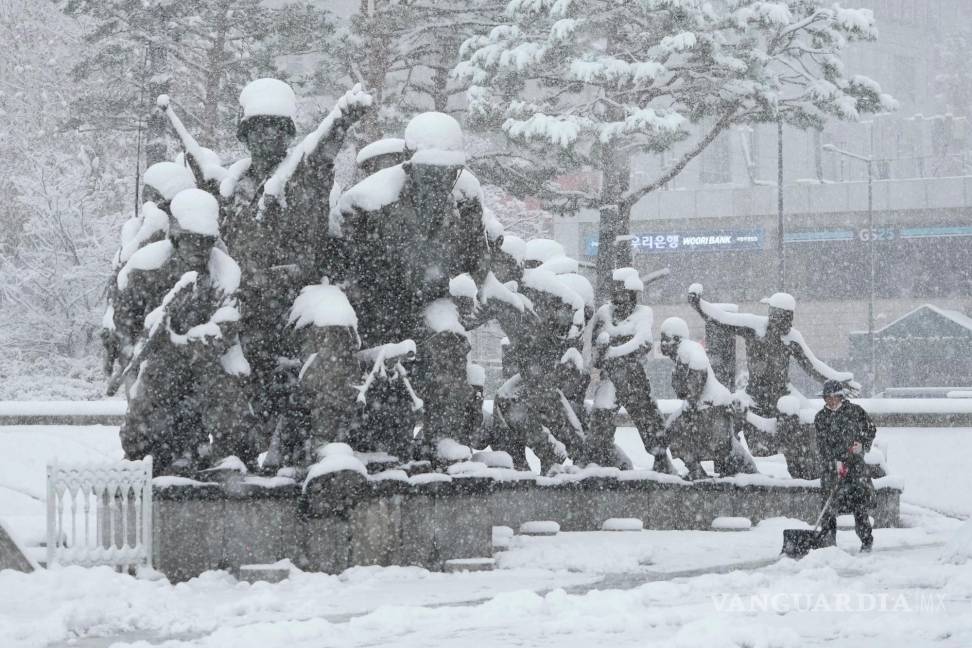 $!Un trabajador quita nieve con una pala cerca de un monumento en recuerdo de la Guerra de Corea en el Museo Memorial de la Guerra de Corea en Seúl.