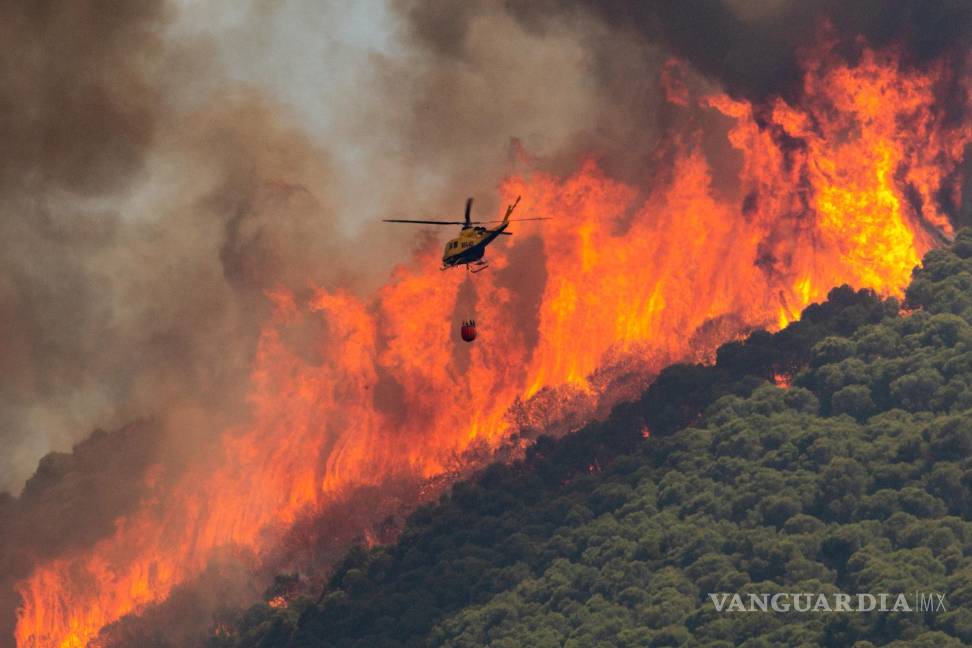 $!Un helicóptero trabaja en las tareas de extinción del incendio declarado este mediodía en el paraje El Higuerón de Mijas (Málaga) en España