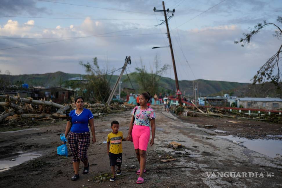 $!Residentes caminan tras el paso del huracán Melissa en El Cobre, Cuba.