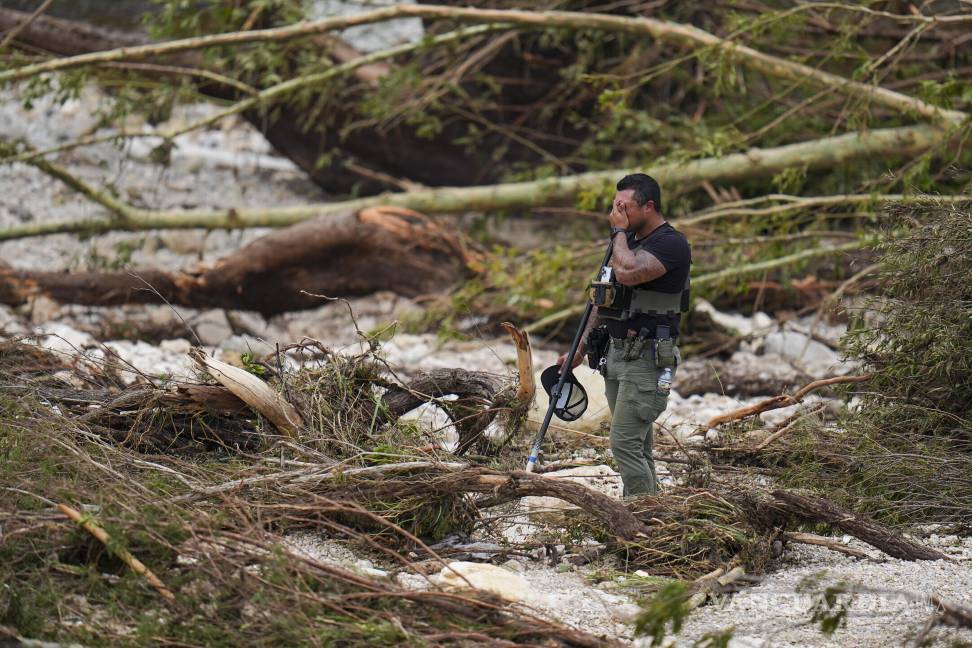 $!Un policía hace una pausa mientras revisa la orilla del río Guadalupe, cerca del Campamento Mystic.