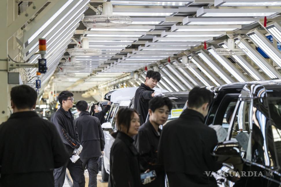 $!Trabajadores en la fábrica de automóviles Zeekr en Ningbo, China. China incrementó sus exportaciones logrando un superávit comercial de más de 1 bdd.