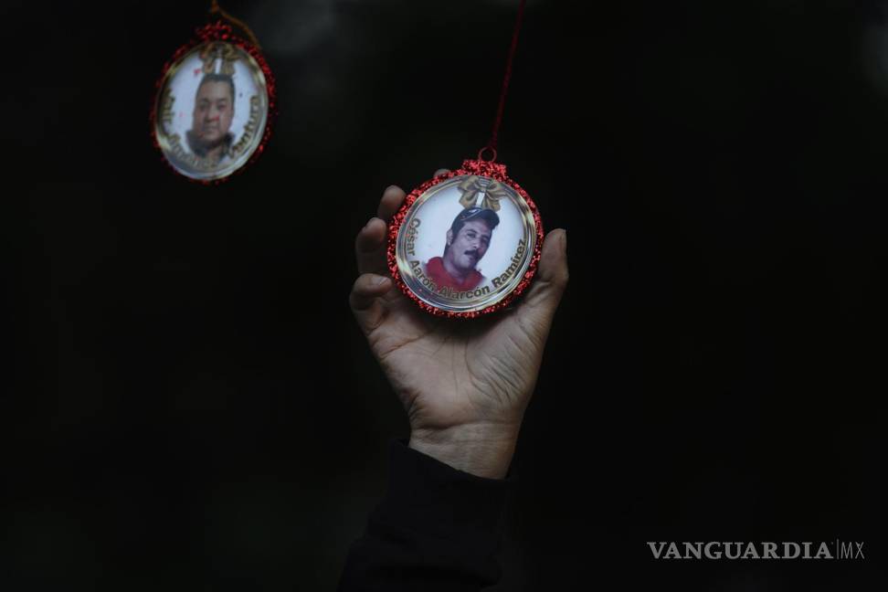 $!Carmela López sostiene una esfera de Navidad con la imagen de su marido desaparecido, César Alarcón, en el Jardín Memorial. AP/Marco Ugarte