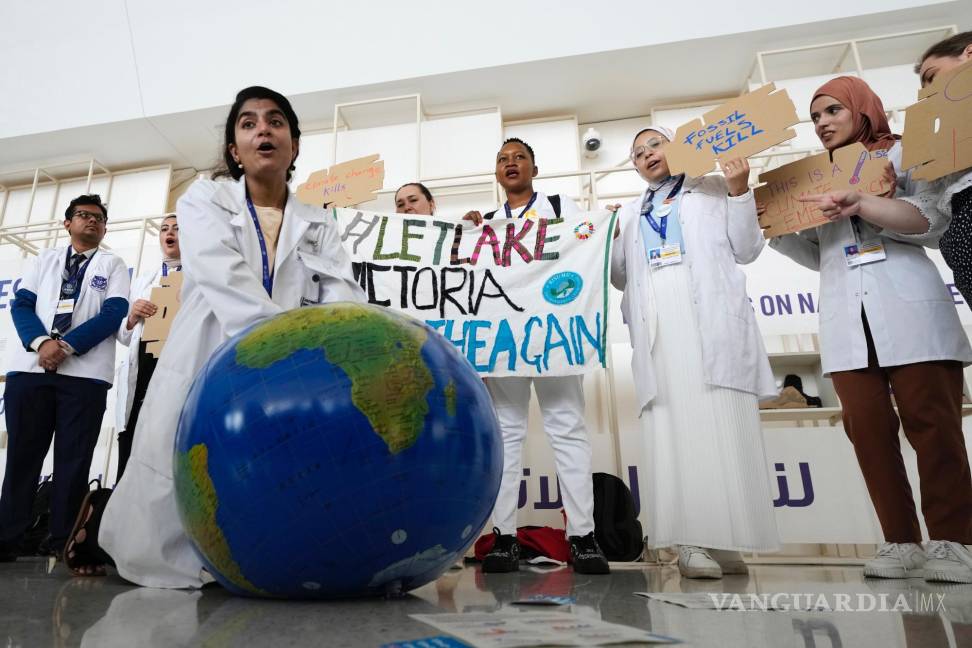 $!Una mujer simula reanimar al planeta Tierra durante una manifestación en la conferencia climática COP28 en Dubái, Emiratos Árabes Unidos.