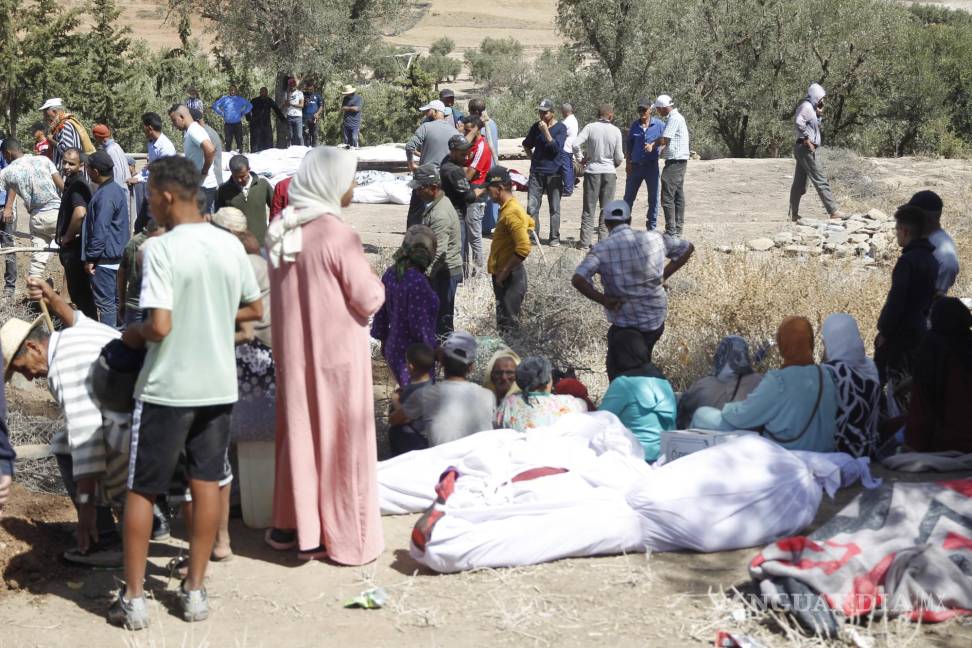 $!Varias personas entierran a sus fallecidos en la aldea][de Tafagajt, en Marruecos, cerca del epicentro del devastador terremoto.
