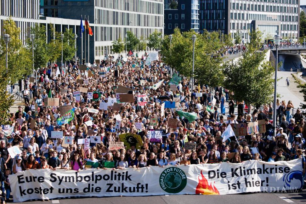 $!Los manifestantes sostienen una pancarta que dice “Su política simbólica nos está costando nuestro futuro” (izq.) y “La crisis climática está aquí” (der.) en Berlín.