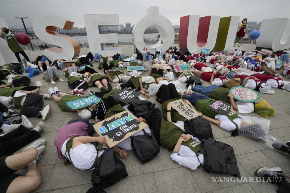 $!Activistas con bolsas de plástico se acuestan en el suelo durante una campaña para conmemorar el Día de la Tierra contra el cambio climático en Seúl.