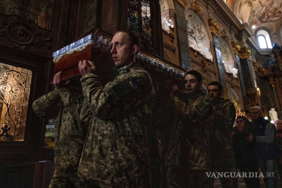 $!La madre del teniente Oliynyk Dmytro, de 40 años, que murió en combate, llora su muerte mientras camina tras el ataúd en su funeral.