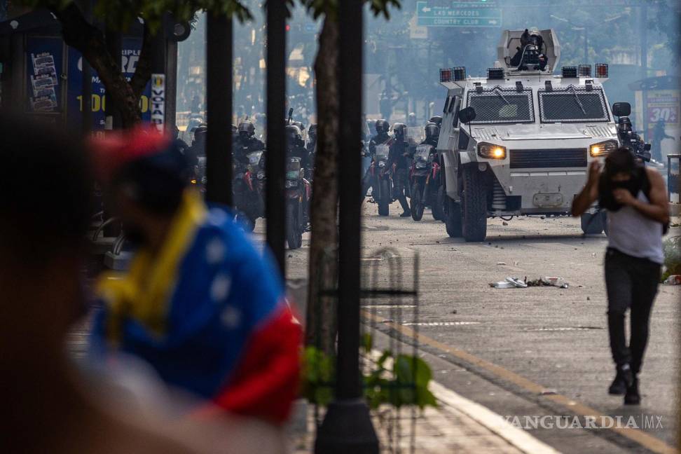 $!Manifestantes corren durante enfrentamientos entre opositores y miembros de la Guardia Nacional Bolivariana (GNB), por los resultados de las elecciones presidenciales este lunes, en Caracas (Venezuela). Protestas en Caracas luego de que el Consejo Nacional Electoral (CNE) proclamara a Nicolás Maduro como presidente reelecto de Venezuela, tras los comicios celebrados este 28 de julio.