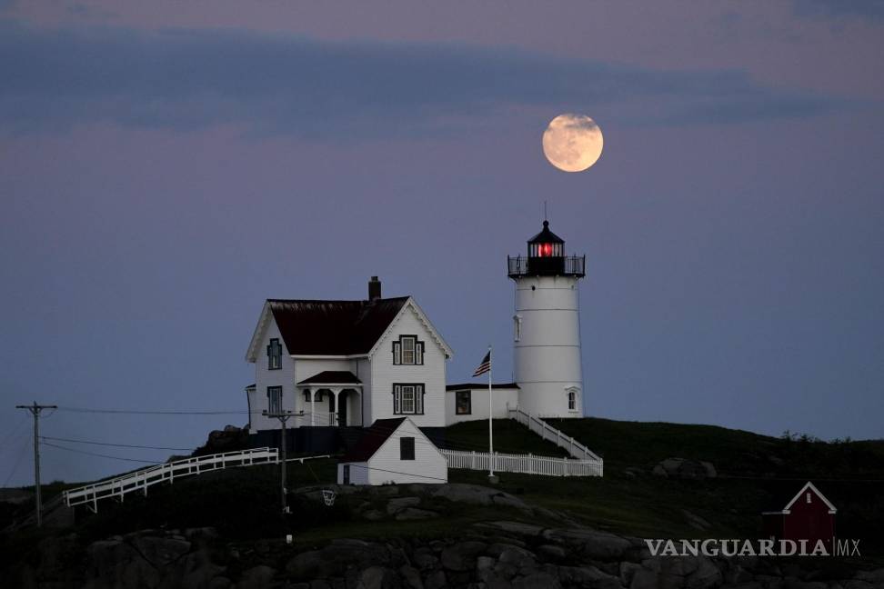 $!La luna se eleva cerca de Nubble Light en York, Maine. (estados Unidos). Durante el fenómeno conocido como la “Luna de la fresa”.