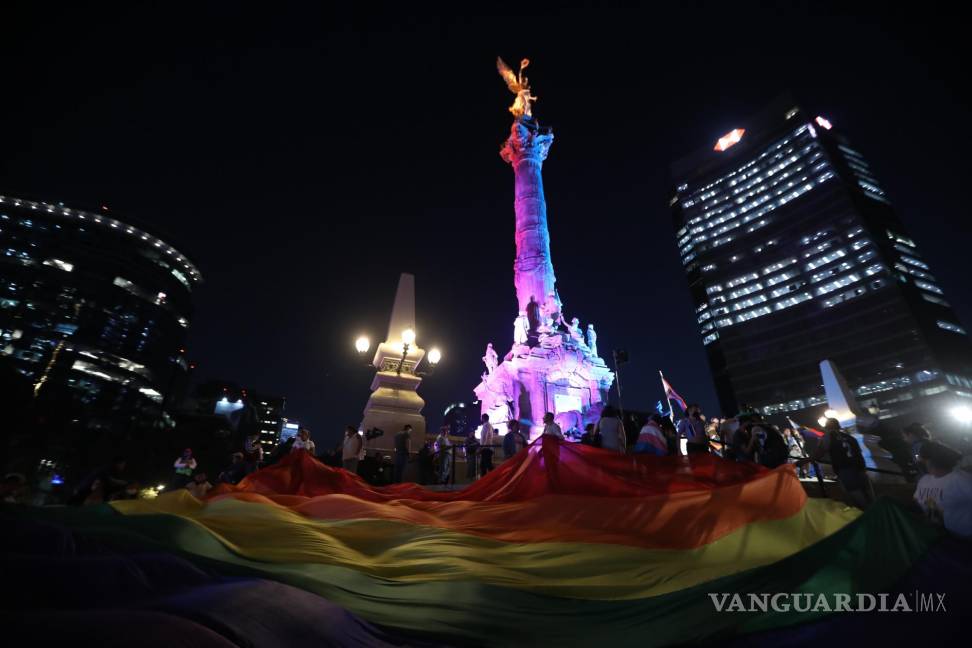 $!Activistas asisten al monumento del Ángel de la Independencia que se iluminó con los colores de la bandera LGBTIQ, hoy en la Ciudad de México (México).