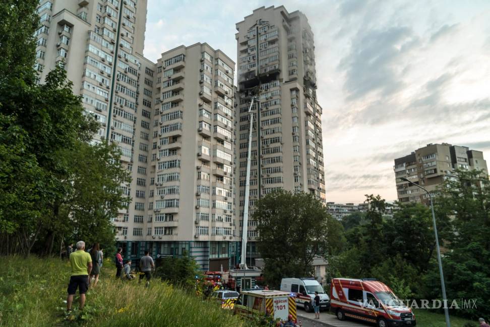 $!Los residentes y los servicios de emergencia se reunieron frente a un edificio residencial de gran altura que fue alcanzado por un misil en Kiev, Ucrania.