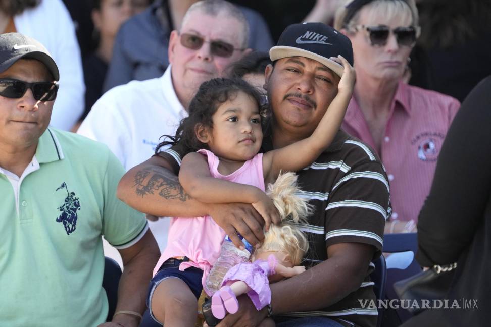 $!El sobreviviente del tiroteo masivo Wilson García sostiene a una niña durante una vigilia por su hijo, Daniel Enrique Laso, en Cleveland, Texas.