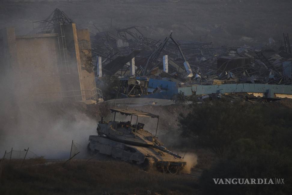 $!Soldados israelíes conducen un tanque dentro de la Franja de Gaza visto desde el sur de Israel.