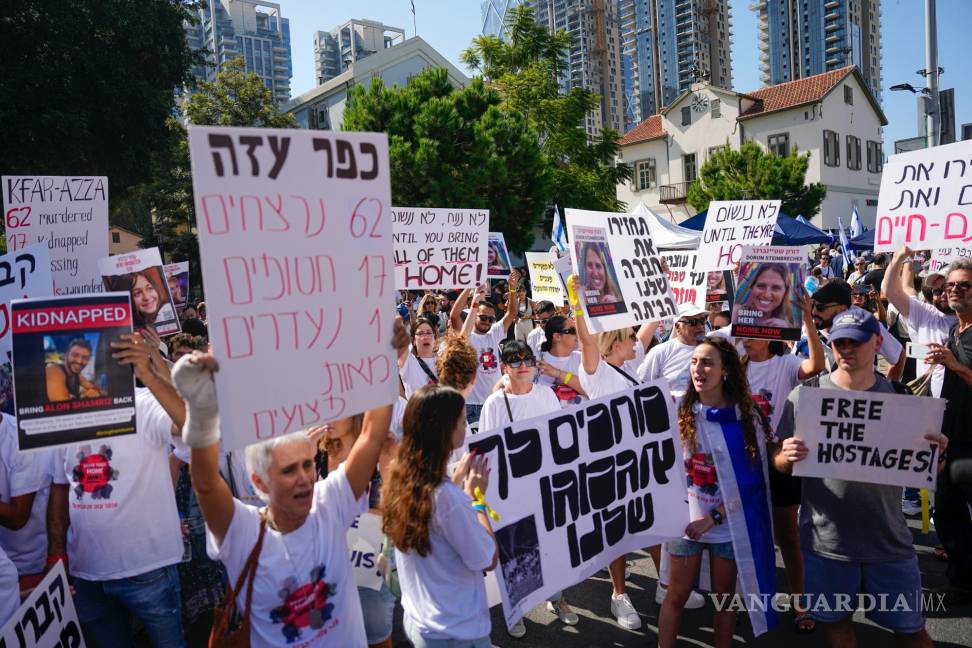 $!Residentes del kibutz Kfar Azza atacada por Hamás, sostienen fotografías de sus seres queridos, piden el regreso de más de 220 rehenes, en Tel Aviv, Israel.