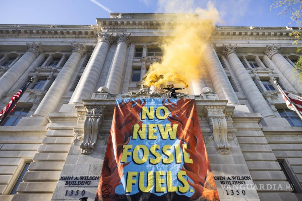 $!Activistas del grupo ambientalista Extinction Rebellion (XRDC) cuelgan una pancarta del Edificio Wilson, la sede del gobierno local de DC, en Washington.