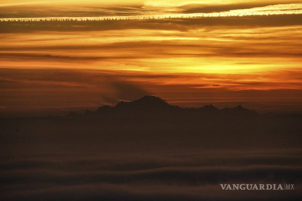 $!Un avión sobrevuela el Mont-Blanc mientras el sol sale en Francia. AP/Laurent Cipriani