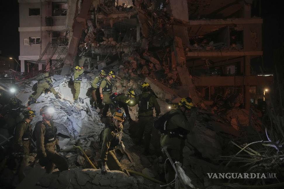 $!Las fuerzas de seguridad israelíes inspeccionan los edificios destruidos que fueron alcanzados por un misil disparado desde Irán, cerca de Tel Aviv, Israel.