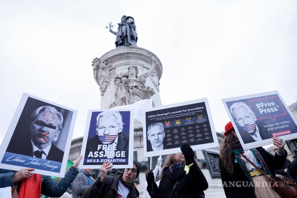 $!Personan sostiene pancartas con retratos de Julian Assange, durante una manifestación para apoyarlo, en la Place de la Republique en París, Francia.