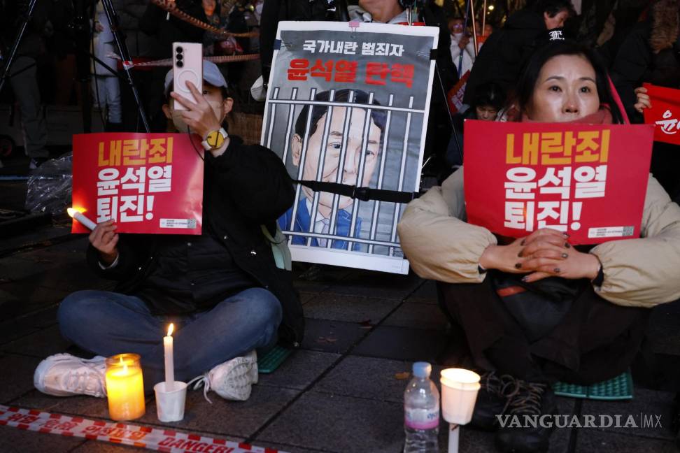 $!Miembros de grupos cívicos y de la Confederación Coreana de Sindicatos (KCTU) sostienen velas y carteles que dicen “¡Yoon Suk Yeol, dimite por traición!”.