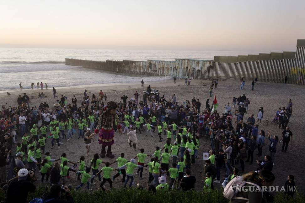 $!La pequeña Amal baila con niños en la playa donde el muro fronterizo que divide a Estados Unidos y México en Tijuana.