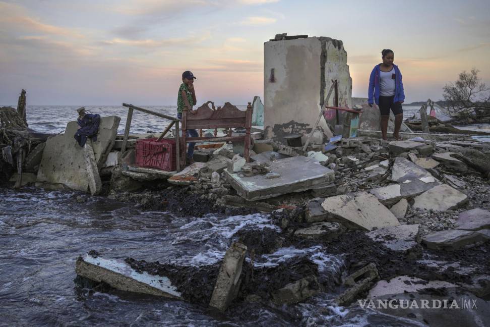 $!Yahir Mayoral y Emily Camacho caminan entre los escombros de la casa de su abuela, destruida por las inundaciones en El Bosque, en el estado de Tabasco.