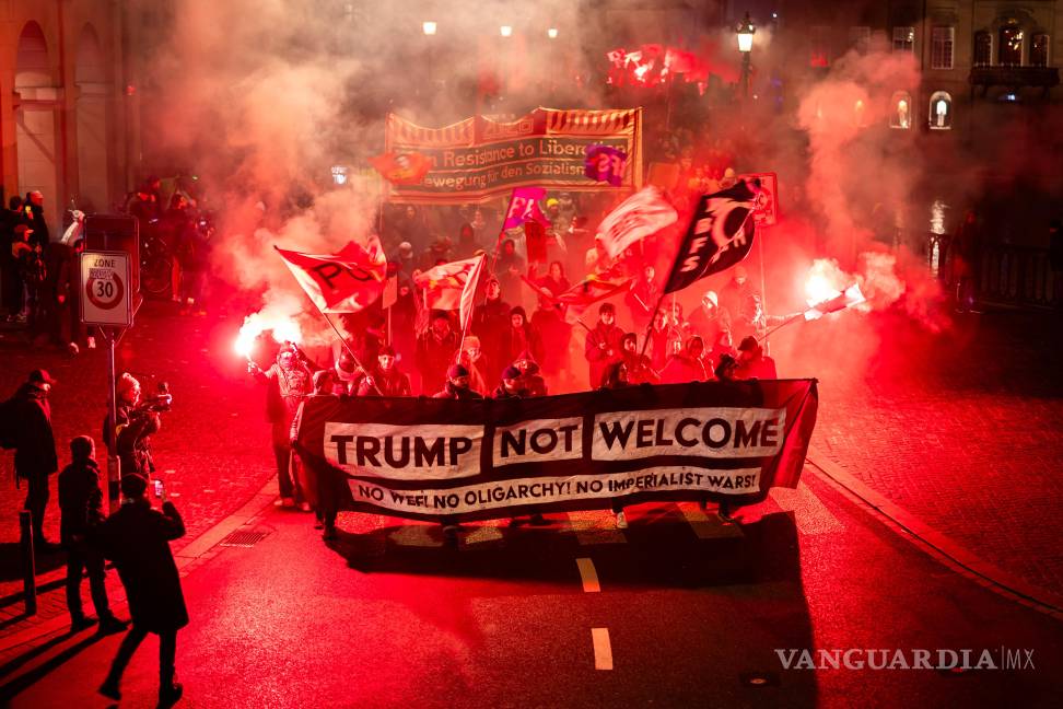 $!Manifestantes sostienen una pancarta con la leyenda “Trump no es bienvenido” durante una protesta contra el Foro Económico Mundial de Davo.