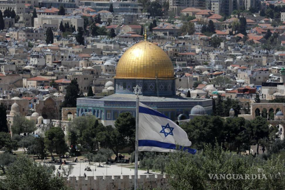 $!La bandera israelí ondea frente a la Ciudad Vieja de Jerusalén y la Cúpula de la Roca, vista desde el Monte de los Olivos en Jerusalén.