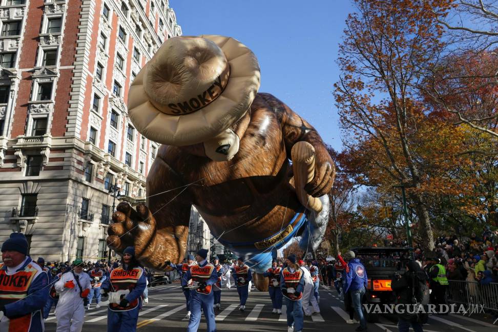 $!Los manipuladores guían el globo Smokey Bear a lo largo de Central Park West durante el desfile del Día de Acción de Gracias de Macy’s en Nueva York.