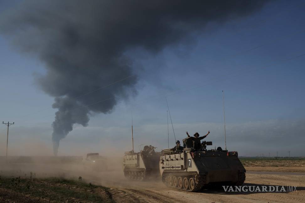 $!Soldados israelíes cerca de la frontera entre Israel y Gaza, con una humareda al fondo, en la Franja de Gaza, vista desde el sur de Israel, el 21 de enero de 2025.