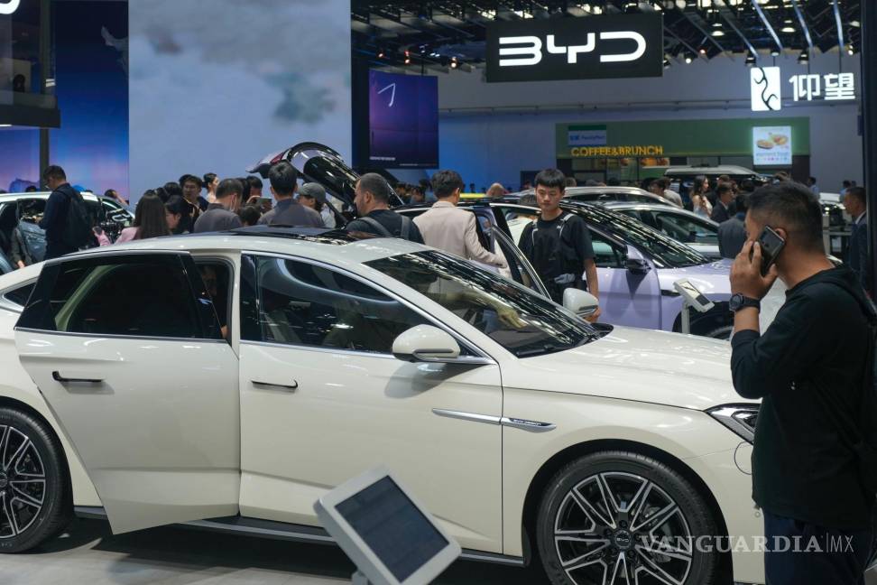 $!Visitantes observan autos en la exposición de BYD en Beijing, China. Los vehículos eléctricos son el más reciente punto de conflicto en una disputa comercial.