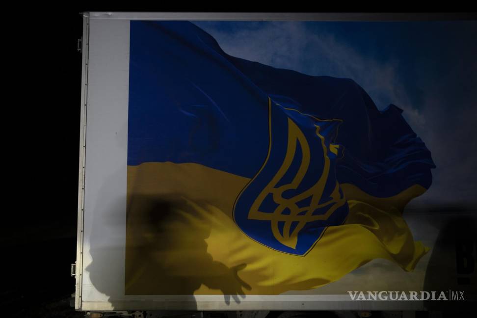 $!Oleksii Yukov proyecta una sombra sobre un camión frigorífico decorado con la bandera ucraniana en la región de Sloviansk, Ucrania.