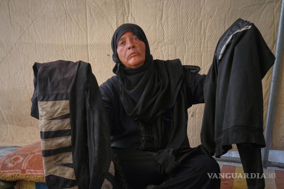 $!Fadwa al-Ghalban sostiene ropa de su hijo Mosaab, en su tienda en Muwasi, Gaza. Fadwa no ha tenido noticias de Mosaab desde julio.