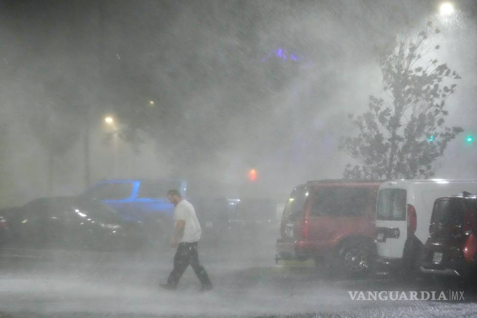 $!Max Watts, de Buford, Georgia, camina por un estacionamiento para revisar un tráiler estacionado en el exterior del hotel donde espera el paso del huracán Milton.