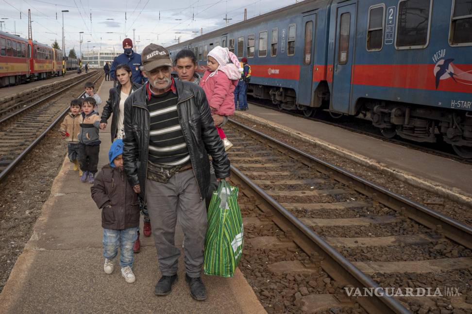 $!Refugiados que huyen de la guerra en la vecina Ucrania caminan sobre un andén en Zahony, Hungría. AP/Balazs Kaufmann