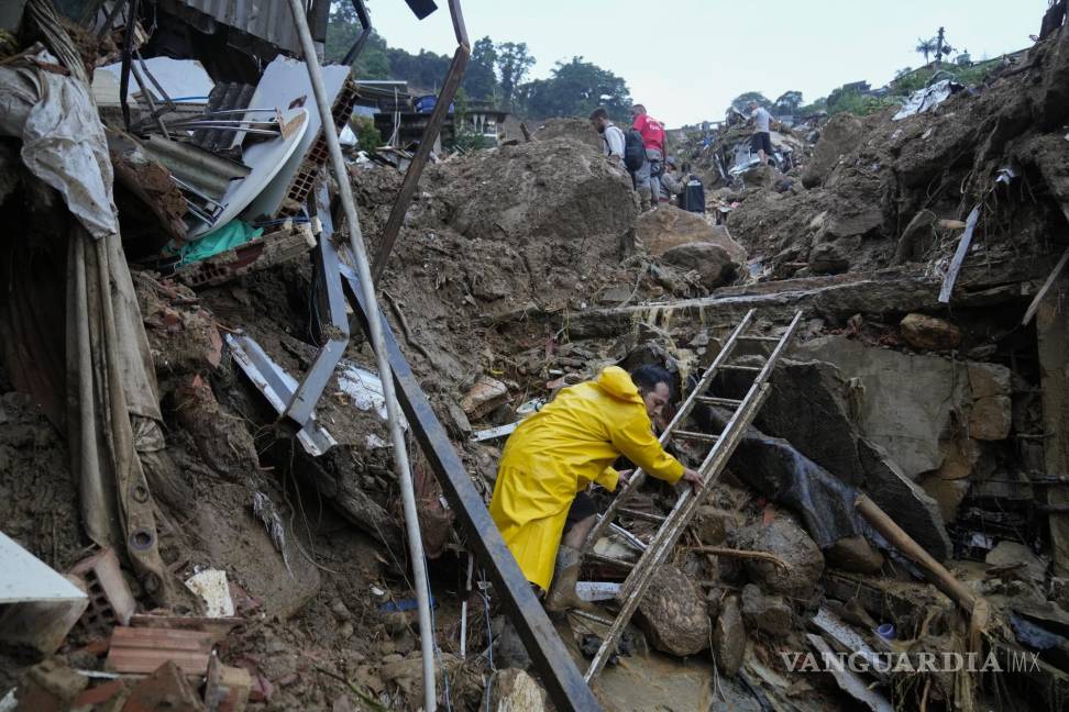 $!Rescatistas y residentes buscan posibles víctimas en una zona afectada por los deslaves luego de lluvias torrenciales, en Petrópolis. AP/Silvia Izquierdo