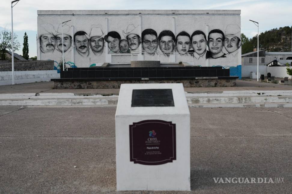 $!Los rostros de 13 residentes muertos a tiros en la plaza del pueblo de Creel, México, cubren una pared como homenaje.