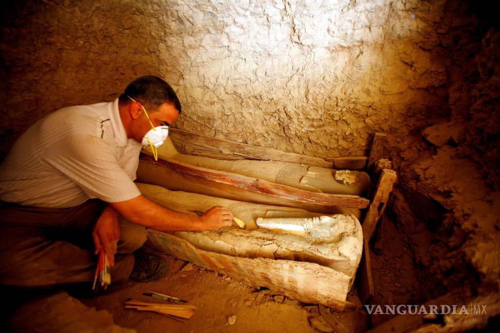 $!Un arqueólogo egipcio limpia un féretro de madera que contiene una momia cubierta con un trapo de lino, en la pirámide Illahun de la localidad egipcia de Faiyum. EFE/Khaled El-Fiqi