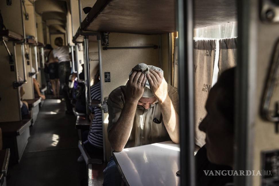 $!Un hombre sostiene su cabeza entre sus manos mientras toma asiento en un tren que evacua a los residentes de Pokrovsk, Ucrania.