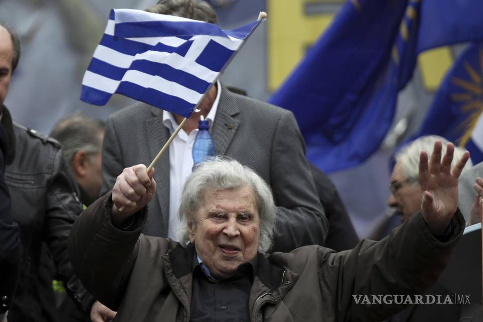 $!En esta fotografía de archivo del domingo 4 de febrero de 2018, el famoso compositor griego Mikis Theodorakis ondea una bandera griega después de su discurso en un mitin en Atenas, Grecia. AP/Petros Giannakouris