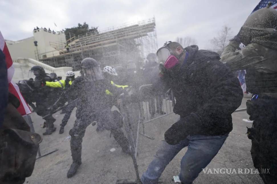 $!Partidarios del entonces presidente Donald Trump intentan atravesar una barrera policial en el Capitolio en Washington el 6 de enero de 2021.