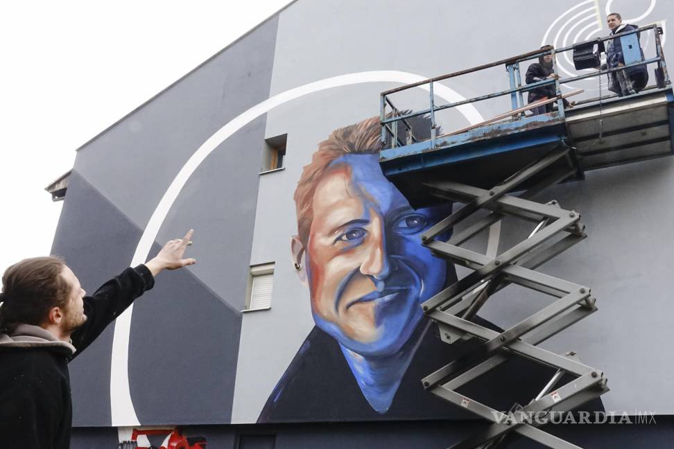 $!Benjamin Cengic habla con sus colegas que aplican los toques finales al mural que representa a Michael Schumacher en Sarajevo, Bosnia. AP/Eldar Emric