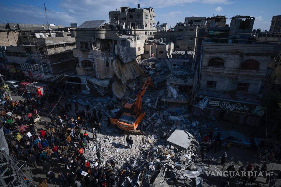 $!Palestinos buscan cadáveres y supervivientes entre los escombros de un edificio residencial destruido en un ataque aéreo israelí en Rafah, Franja de Gaza.