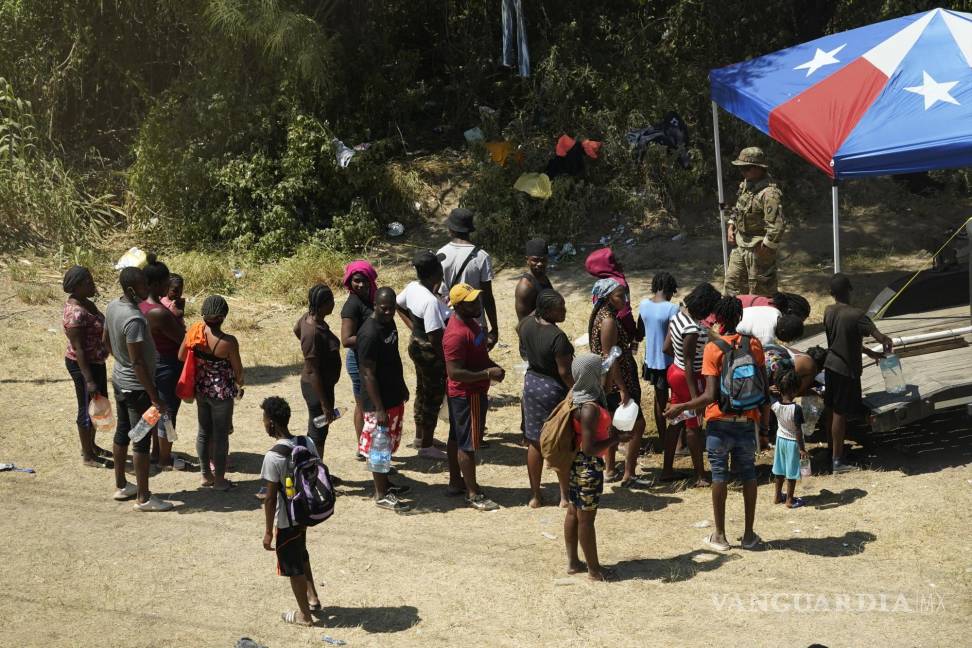 $!Migrantes haitianos hacen fila para buscar agua después de cruzar a Estados Unidos desde México en Del Rio, Texas. AP/Eric Gay