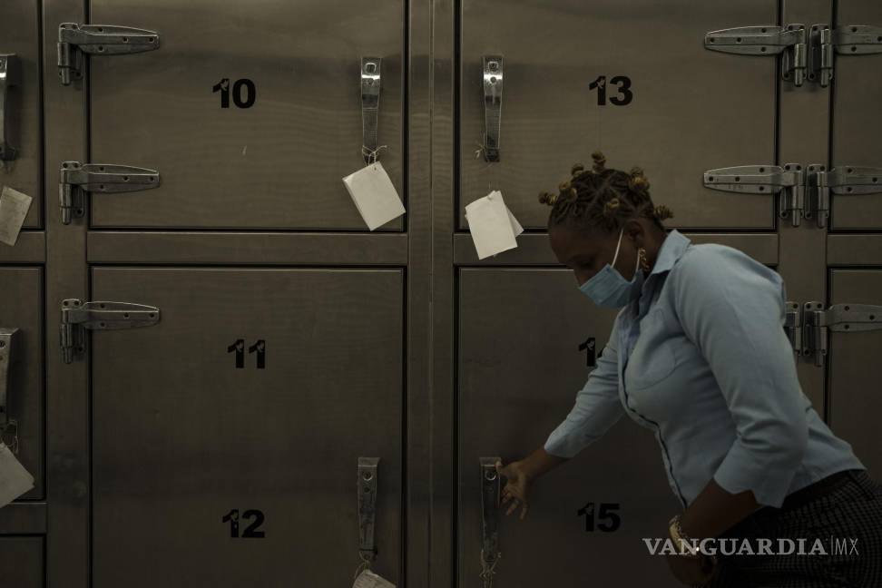 $!Una técnica forense abre la puerta de una cámara frigorífica donde se guardan los restos mortales de los migrantes que iban a bordo de un cayuco mauritano.